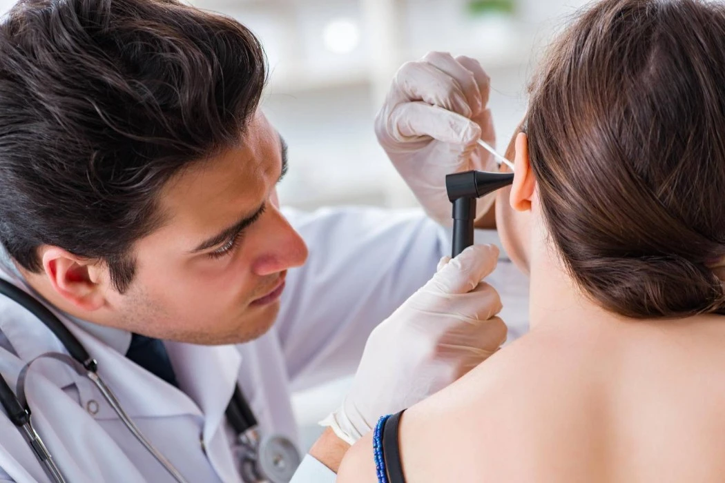 Pharmacist perfoming ear wax microsuction treatment
