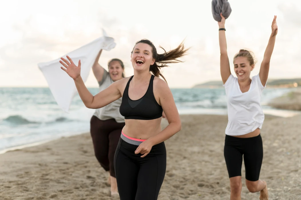 Three women running on the beach
